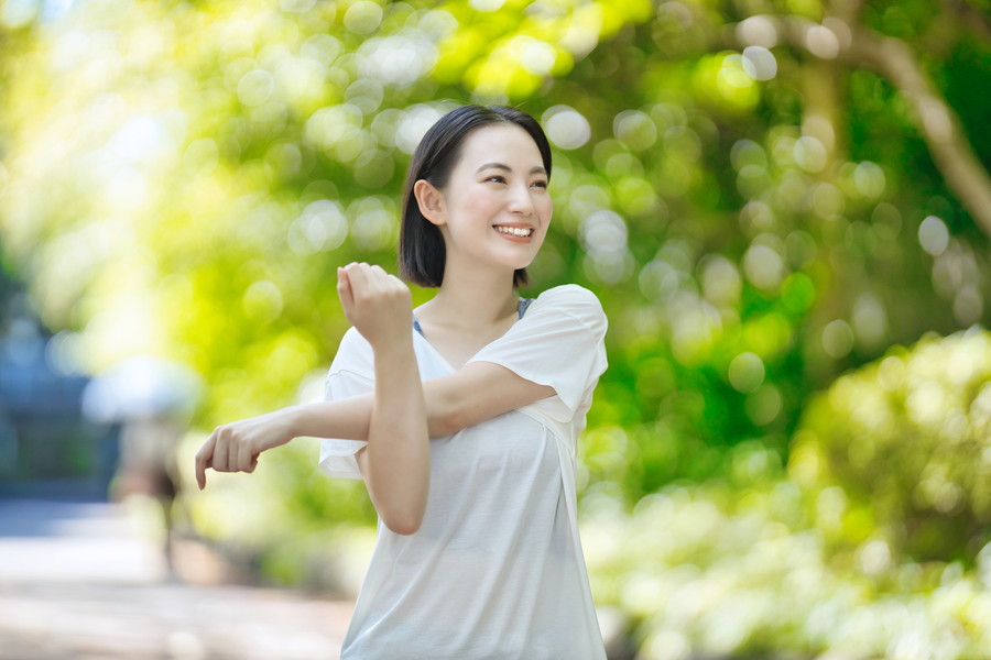 笑顔で元気に外で運動している女性