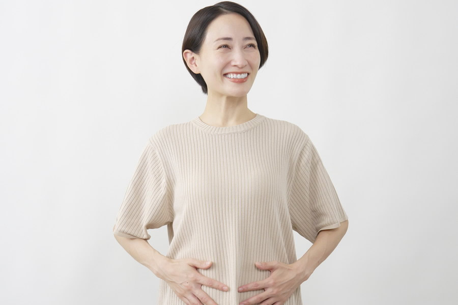 お腹を触って笑顔の女性
