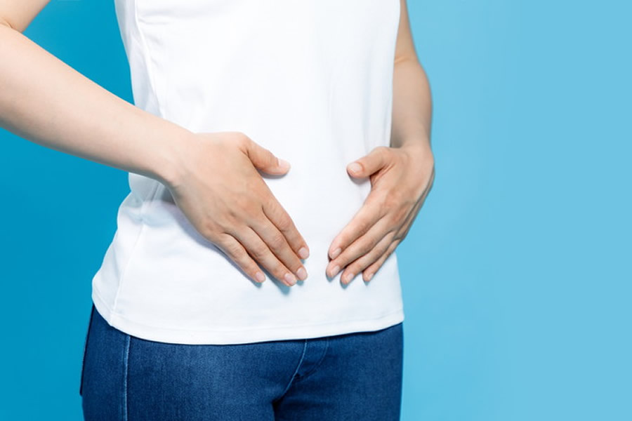お腹に軽く手を添えている女性