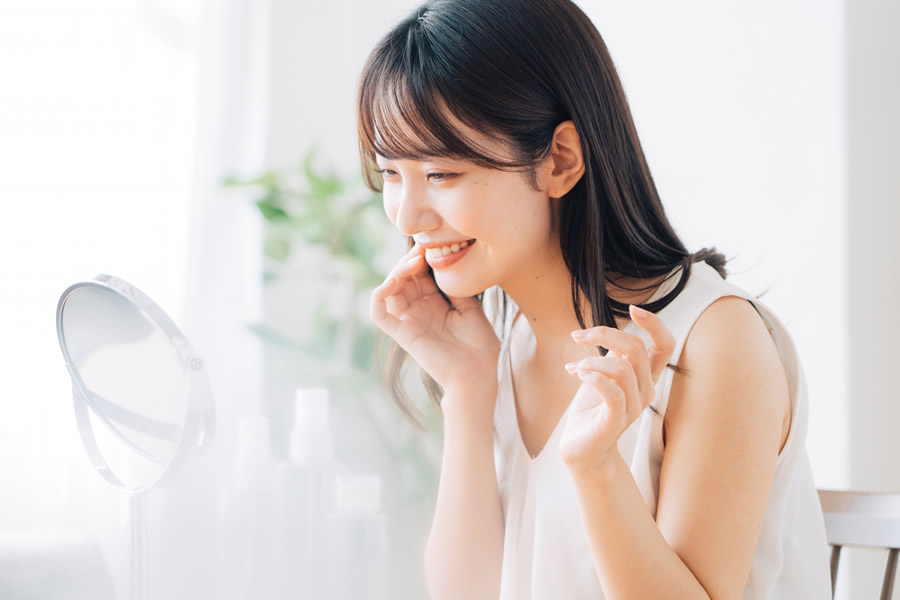 鏡を見て笑顔の女性