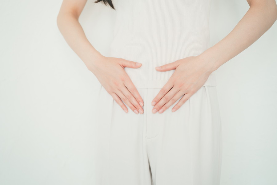 腸に軽く手をあてている女性
