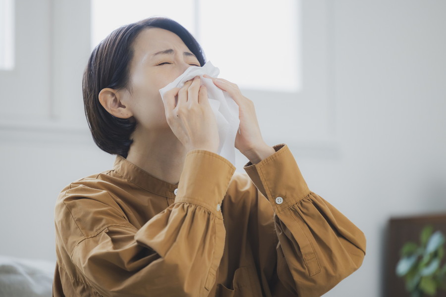 花粉症でつらそうにしている女性