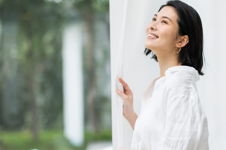 窓を開けている笑顔の女性