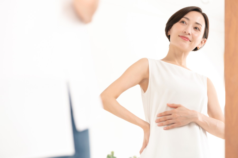 鏡で自分のウエストを見ている女性