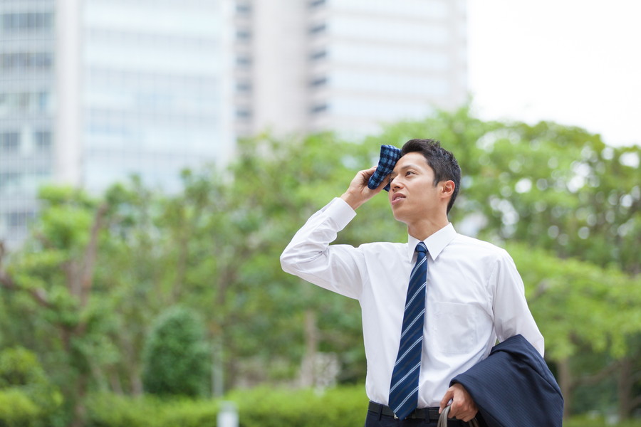 外で夏バテになっている男性