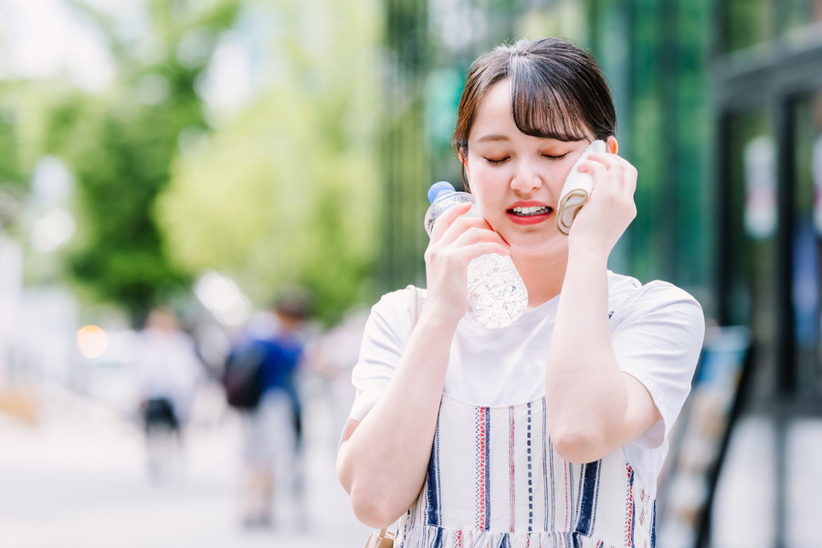 外で夏バテになっている女性
