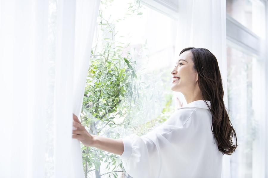 笑顔まどの外をみている女性